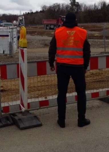 SOX-Sicherheitskraft in Warnweste bei der Bewachung einer Baustelle
